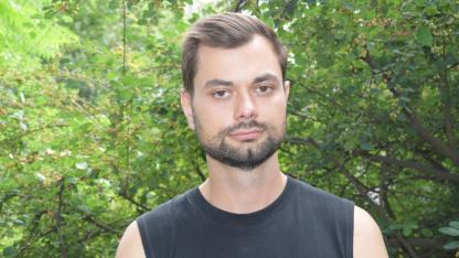 Porträt von Borys Hrachov im schwarzen Top vor grünen Bäumen